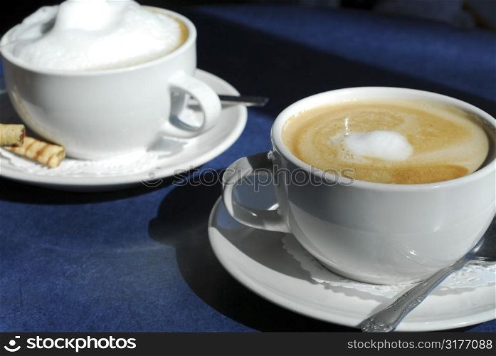 Cappuccino and Latte in cups with saucers