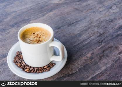 Cappuccino Coffee in a white cup set and coffee been on the gray wooden table with copy space