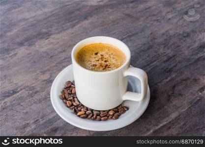 Cappuccino Coffee in a white cup set and coffee been on the gray wooden table with copy space