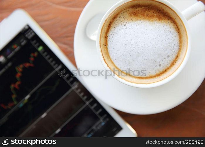 cappuccino coffee on wood background with tablet stock