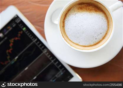cappuccino coffee on wood background with tablet stock