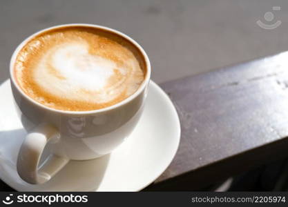 Cappuccino in white cup on sunlight at cafe. Copyspace. Bewerages, coffee lovers and morning menu concept. Nature background.. Cappuccino in white cup on sunlight at cafe. Copyspace. Bewerages, coffee lovers and morning menu concept. Brown background