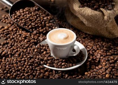 Cappuccino or Coffee with milk cup and roasted beans. Coffee background