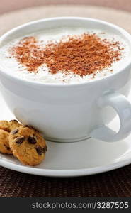 Cappuccino or latte coffee in cup with frothed milk and cookies