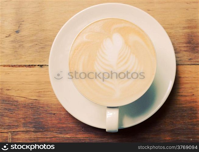 Cappuccino or latte coffee on table with retro filter effect