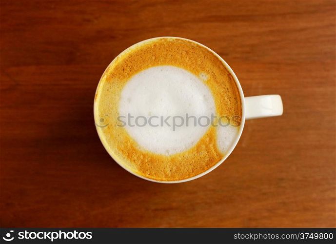 Cappuccino or latte coffee on wooden table