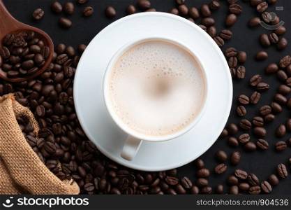 Cappuccino or latte with foaming foam and coffee beans, white coffee cups on the table, top view