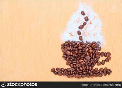 Cappuccino time. Roasted coffee beans placed in shape of cup and saucer with cinnamon white froth on wooden surface background
