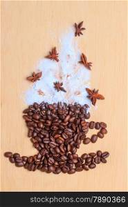 Cappuccino time. Roasted coffee beans placed in shape of cup and with white froth anise decoration on wooden surface background