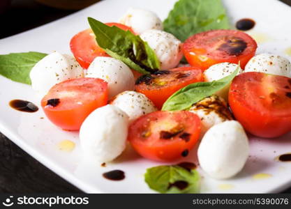 Caprese: cherry tomato, mozzarella balls and basil leaves