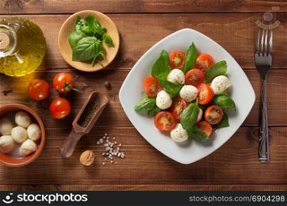 caprese salad and ingredients at wood