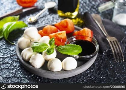 Caprese salad. Healthy meal with cherry tomatoes, mozzarella balls, spices, fresh rocket and basil. Home made, tasty food. Symbolic image.. Caprese salad. Healthy meal with cherry tomatoes, mozzarella balls, spices, fresh rocket and basil.