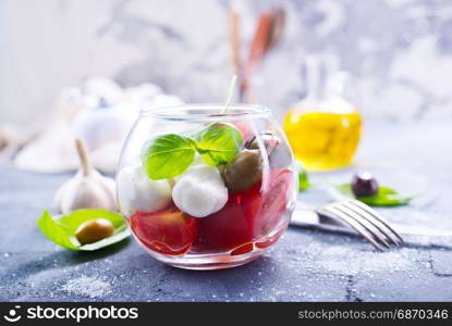 caprese salad in glass bowl and on a table