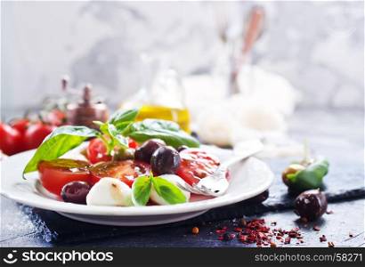 caprese salad on plate and on a table