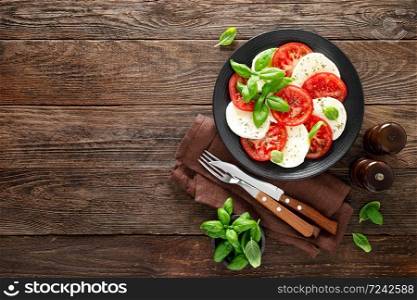 Caprese salad. Salad with mozzarella cheese, fresh tomatoes, basil leaves and olive oil. Italian cuisine