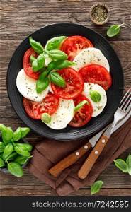 Caprese salad. Salad with mozzarella cheese, fresh tomatoes, basil leaves and olive oil. Italian cuisine