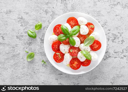 Caprese salad. Salad with mozzarella cheese fresh tomatoes, basil leaves and olive oil. Italian food