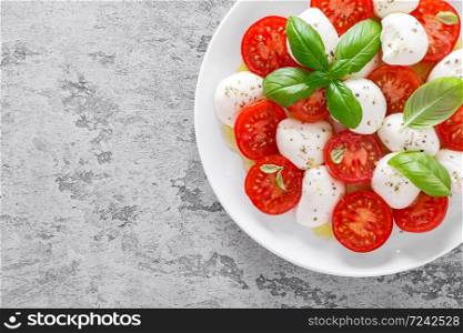 Caprese salad. Salad with mozzarella cheese fresh tomatoes, basil leaves and olive oil. Italian food