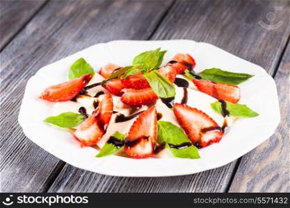 Caprese salad with strawberry, mozzarells, basil and balsamic