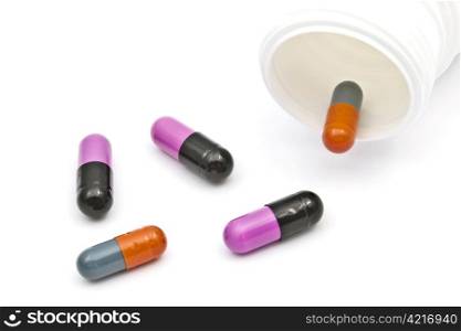 Capsules and bottle closeup on white background