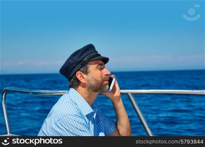 Captain cap sailor man talking mobile phone in boat sailng in the ocean sea