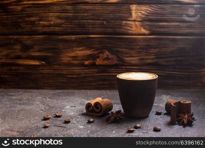 Capuccino in handmade clay cup with cinnamon and anise spices. Capuccino with spices