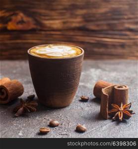 Capuccino in handmade clay cup with cinnamon and anise spices. Capuccino with spices