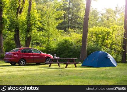 car and a tent on the lawn at the camping