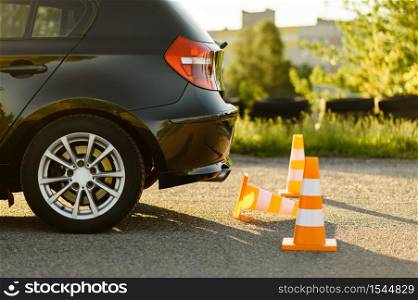 Car and orange traffic cones, lesson in driving school concept, nobody. Teaching to drive vehicle theme. Driver&rsquo;s license education. Car and traffic cones, driving school concept