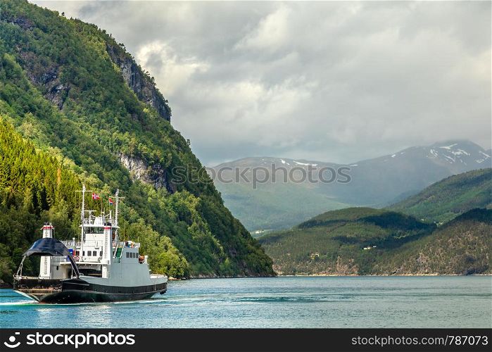 Car and passenger ferry crossing the fjord with mountain landscape in the background, Tafjord, More og Romsdal county, Norway.Norway