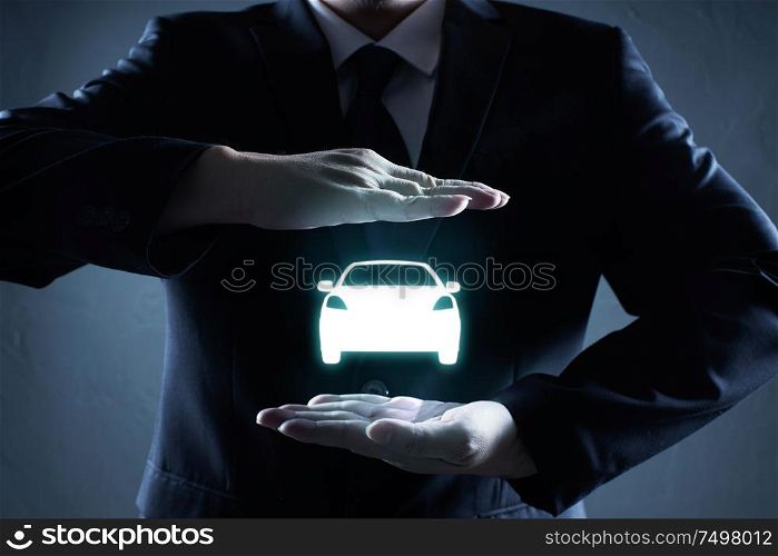 Car (automobile) insurance and collision damage waiver concepts. Businessman with protective gesture and icon of car.