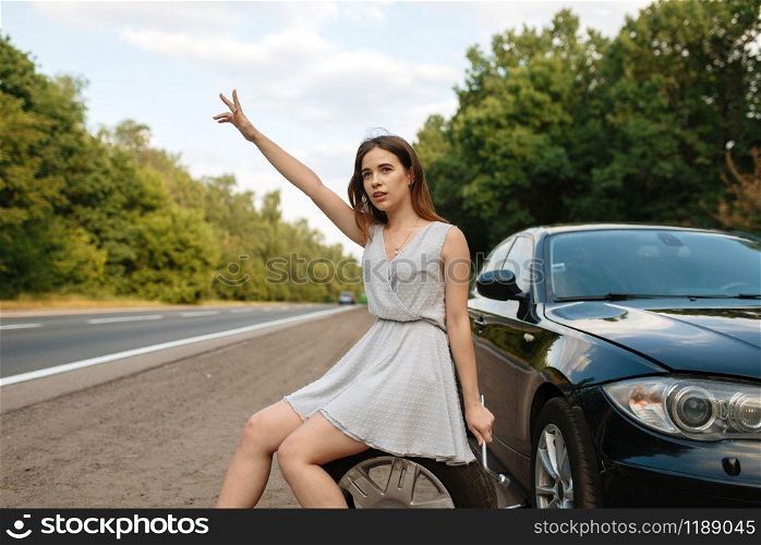Car breakdown, young woman vote on the road, flat tyre. Broken automobile or problem with vehicle, trouble with punctured auto tire on highway