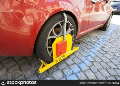 Car clamped on cobbled street