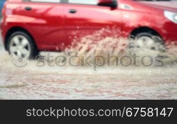 car crossing a flooded road after strong rain