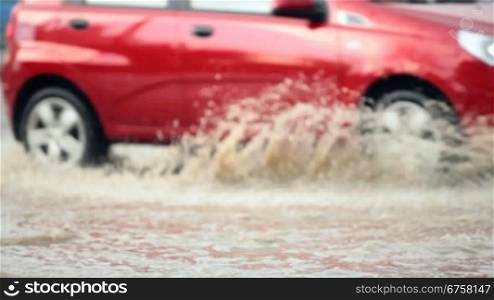 car crossing a flooded road after strong rain