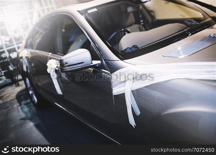 Car decorating with white ribbon and flower or weddings couple after the ceremony