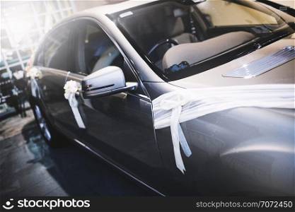 Car decorating with white ribbon and flower or weddings couple after the ceremony