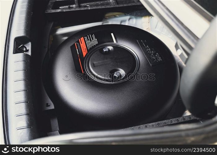 Car donut-shaped LPG tank in a spare wheel hole on the car trunk