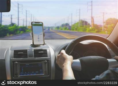Car driver using smartphone with GPS map navigation application while driving on highway, view from inside car