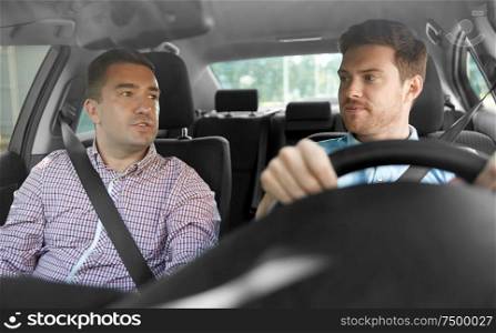 car driving lesson and carpooling concept - instructor on passenger seat and young driver talking. car driving school instructor and male driver