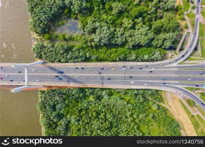 Car driving on highway bridge and road intersection in modern city aerial view