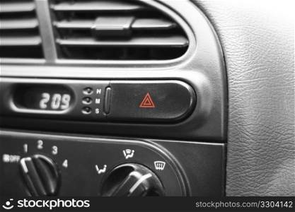 Car emergency lights button on cockpit. Very shallow DOF, focus on triangles on emergency lights button.