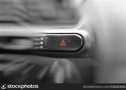 Car emergency lights button on cockpit. Very shallow DOF, focus on triangles on emergency lights button.