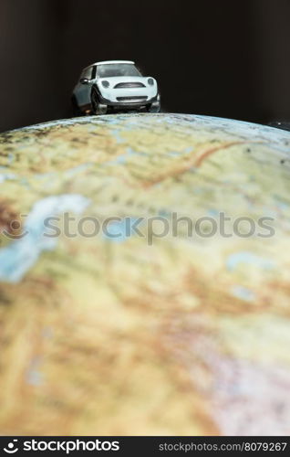 Car figure on globe. Miniature car toy