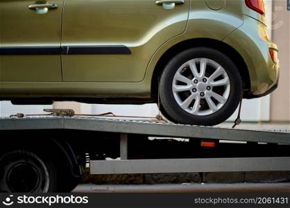 Car fixed on tow truck with metal winch and hooks. Vehicle problem on road. Closeup cropped image.. Closeup car fixed on tow truck vehicle