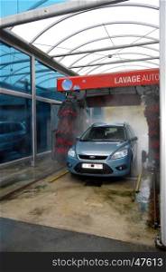 Car in a center of automatic wash with rollers.