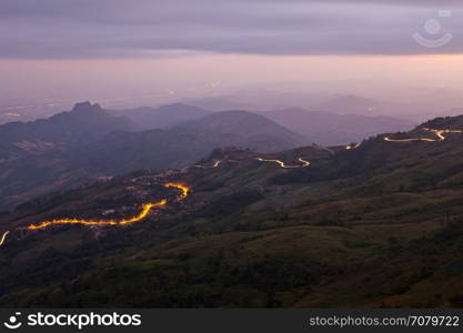 Car light in night on road in mountain.