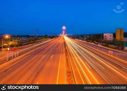 Car light trails on highway street or road in Bangkok, Thailand. Urban city at night in transportation, business, or technology concept. Wallpaper fast motion speed background. Long exposure.