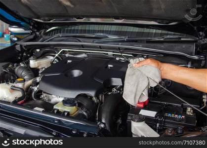 car mechanic checking oil level