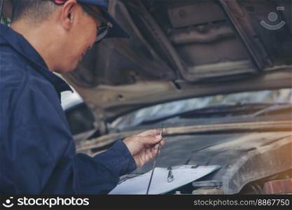 Car Mechanic man hand checking dipstick engine oil car mechanical on site service. Close up hand man check engine oil level Locate dipstick, wipe clean, check dipstick level before fill up engine oil